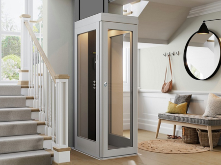 A modern home elevator lift installed next to a staircase in a residential interior. In low cost.