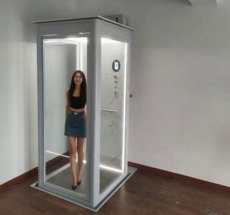 A lady stand inside a modern residential home elevator