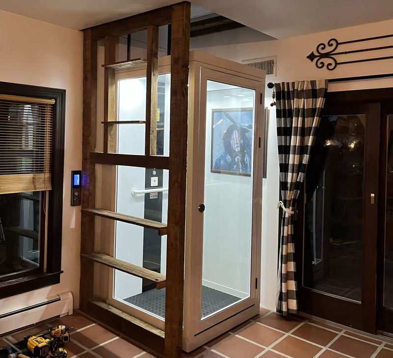 a white home elevator installed at the corner of the house