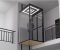 A modern home elevator featuring a glass enclosure and a person standing inside it.