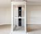 How Much Does A Home Elevator Cost. It's Interior view of a modern home elevator with glass walls and control panel.
